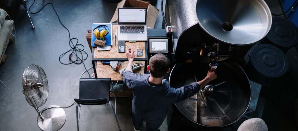 Birds eye view of a man working over a coffee bean roaster