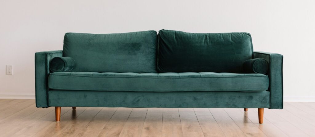 Green couch in an empty room