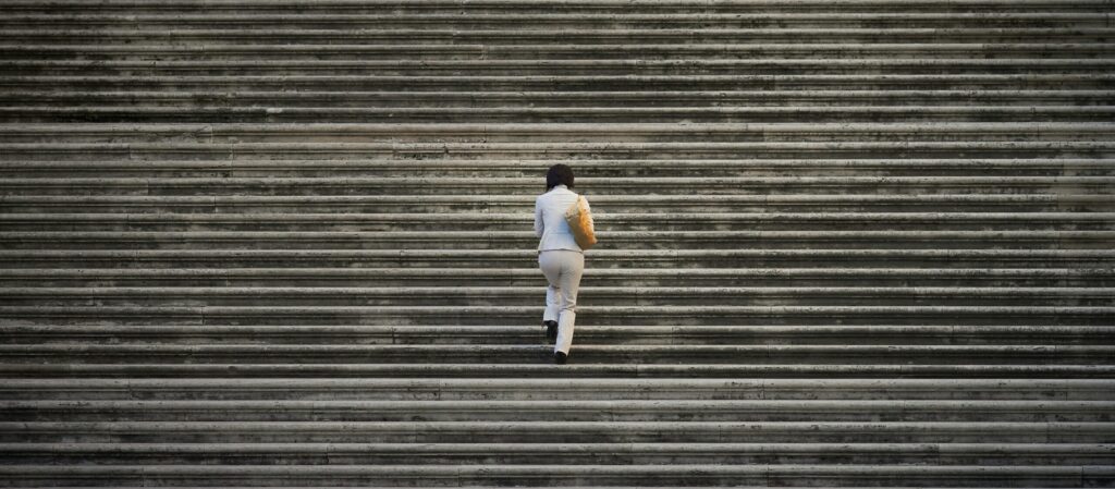 Woman walking up endless stairs