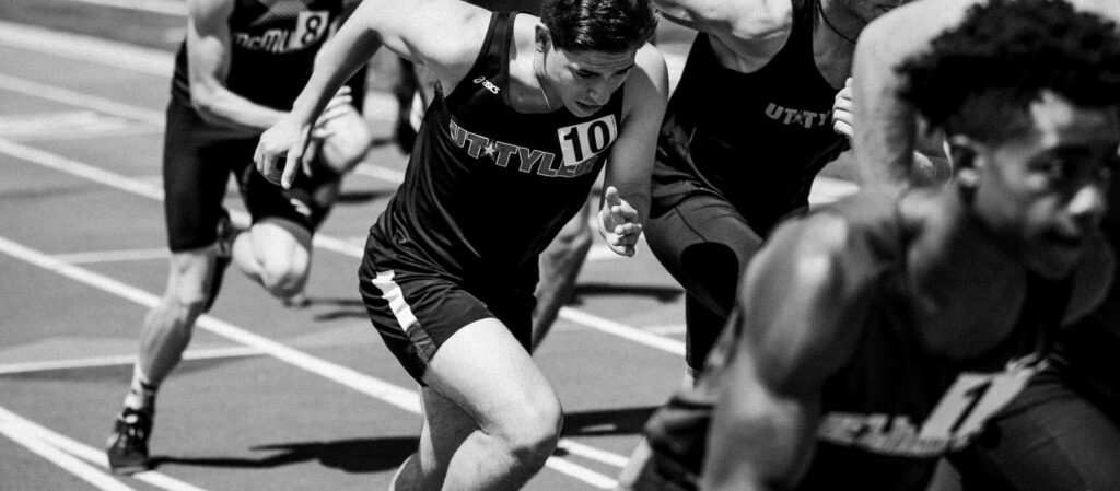 Black and white of students running in a track race