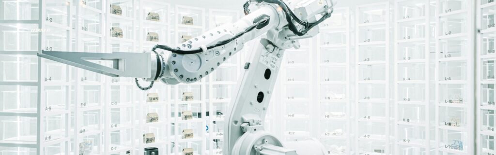 Robot arm in a white room surrounded by test samples